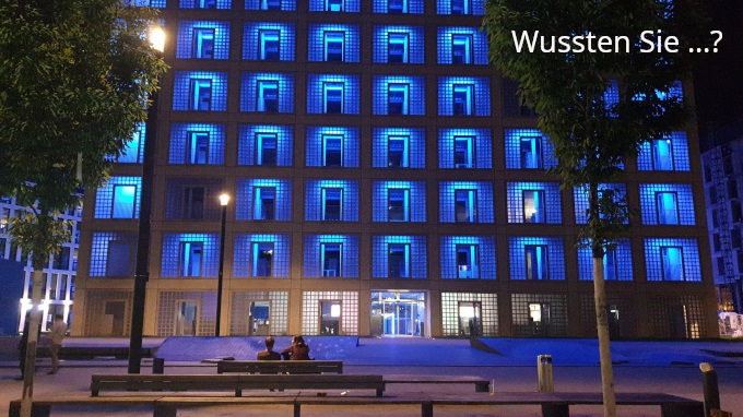 Außenansicht Bibliotheksgebäude blau leuchtend in der Dunkelheit mit dem Schriftzug: Wussten Sie?